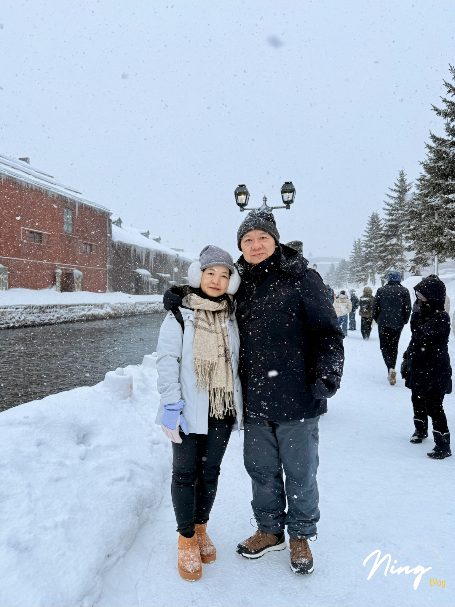 two people standing by Otaru Canal during heavy snowfall in winter